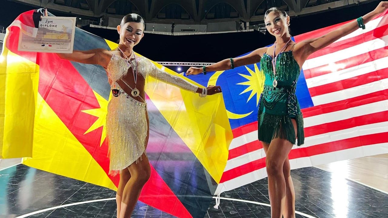 Cordelia Wee at left with Amy Kho showing off their medals and certificates for their WDSF Adult Female Solo Latin event 4th & 6th Placings respectively.