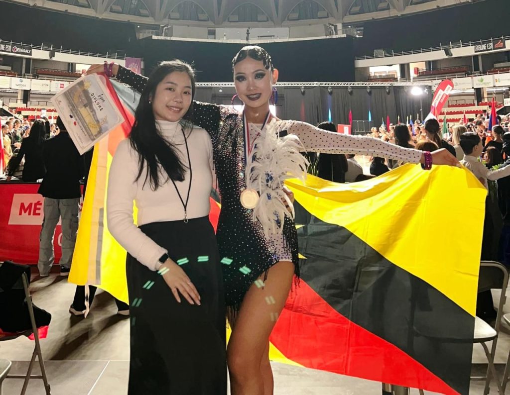 Team manager cum coach Cindy Chung with her protégé Eunice Ling showing off her WDSF Female Youth Solo Latin event 4th Placing medal and certificate.